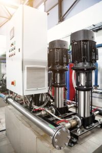 Industry pumps in an technical room. Industrial interior of water pump, valves, pressure gauges